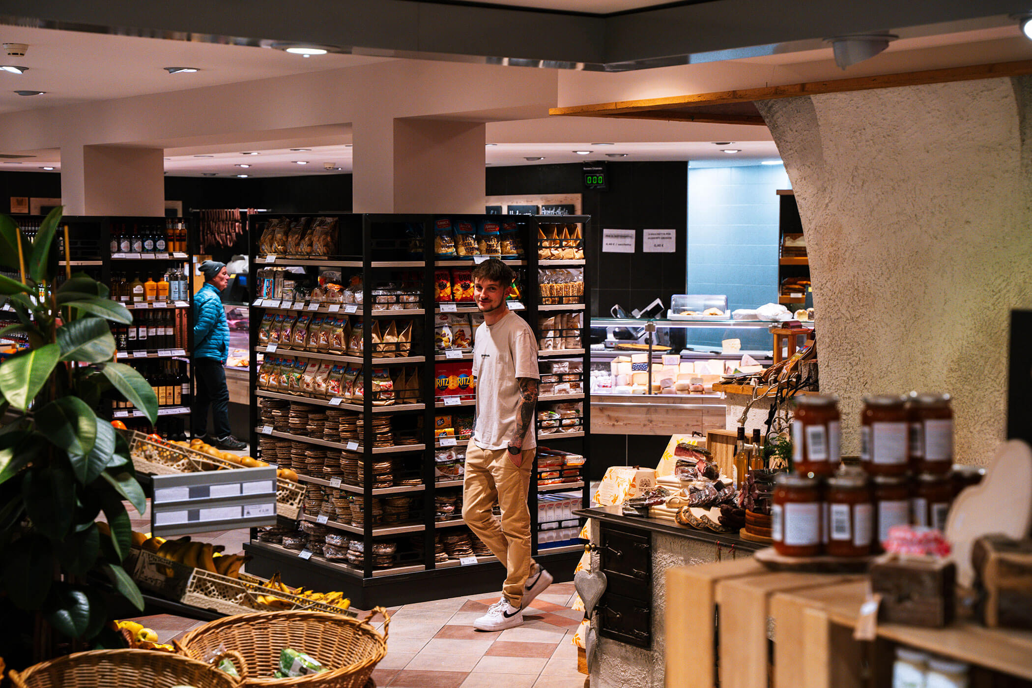 Junger Mann steht in der Metzgerei Senfter zwischen den regionalen Produkten